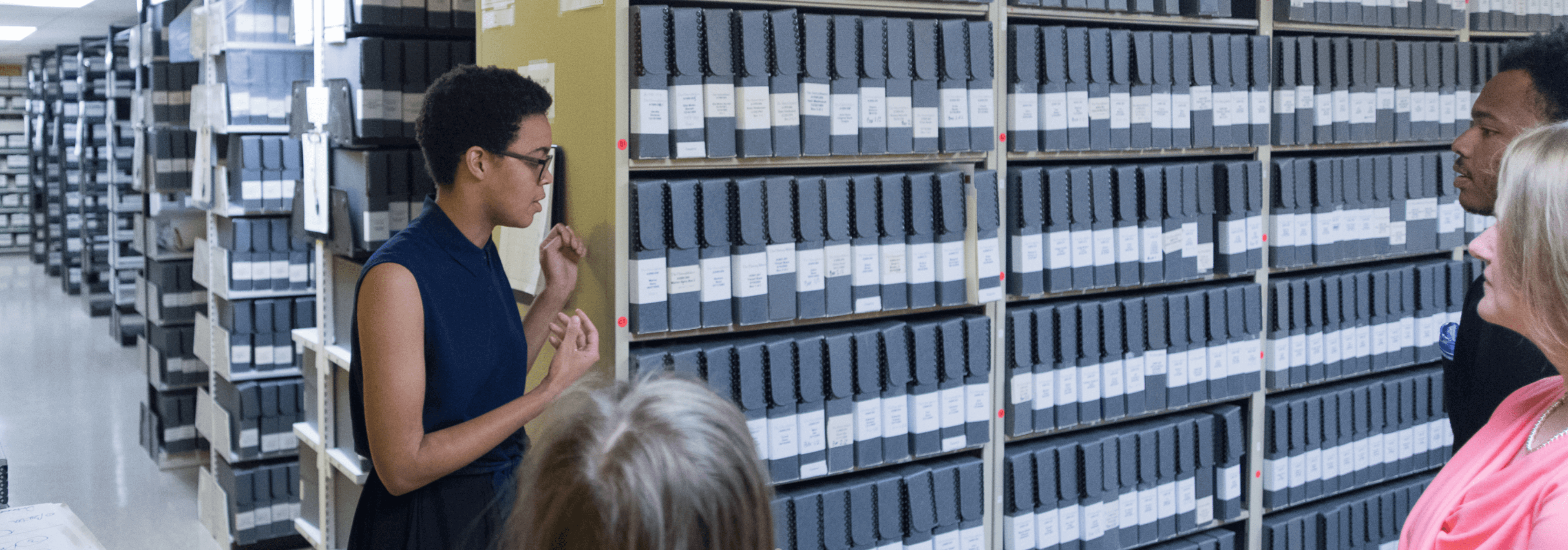 Person showing a group of people what looks to be archives